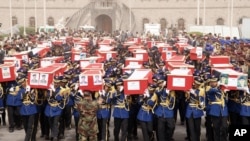 In this handout photo provided by the Defense Ministry, Yemeni officers and soldiers carry coffins of soldiers who were killed in a suicide bomb attack at a parade square in Sanaa, Yemen, May 24, 2012. 