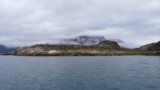 Rumah akomodasi bagi para turis terlihat berada di atas bukit di dekat Maniitsoq, di pesisir barat Greenland, pada 3 September 2024. (Foto: AFP/James Brooks)