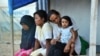 Ibu-ibu dan seorang anak perempuan duduk di depan tenda merea di hunian sementara di Palu, Sulawesi Tengah, 25 September 2019, sebagai ilustrasi. (Foto: AFP)