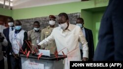 Le président de la Guinée, Alpha Condé vote dans les urnes lors des élections présidentielles à Conakry le 18 octobre 2020.