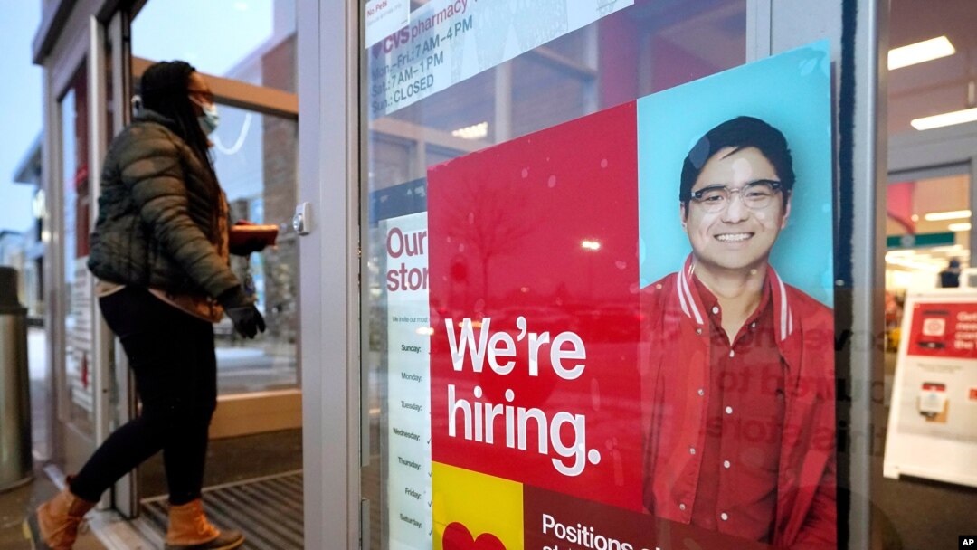 A passer-by walks past an employment hiring sign at a Target store, Feb. 9, 2021, in Westwood, Massachusetts.