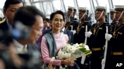 Penasihat Negara dan Menlu Myanmar Aung San Suu Kyi (tengah) berjalan melewati pasukan kehormatan Thailand setibanya di bandara Suvarnabhumi, Kamis (23/6). 