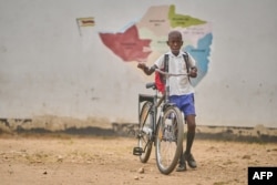 FILE — Joaquim Homera, a primary school learner heads to park his bicycle at school at Mabale primary school near Hwange National Park in Hwange on March 8, 2024.