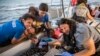 Doctors tend to a pregnant woman on a Mediterranea Saving Humans NGO boat, as they sail off Italy's southernmost island of Lampedusa, just outside Italian territorial waters, July 4, 2019. 