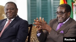 Zimbabwean President Robert Mugabe (R) and Prime Minister Morgan Tsvangirai announce the resolution of longstading disputes over a draft constitution at a press conference in Harare, January 17, 2013.