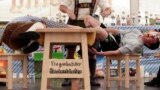 A judge watches the leather ring held by two competitors with their middle fingers at the Alps Finger Wrestling championships in Reichertshofen, southern Germany. Competitors battle for the title in this traditional rural sport where the winner has to pull his opponent over a marked line on the table.