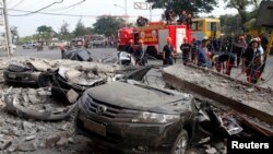 آتش نشانان در نزدیکی یک خودرو که بر اثر زمین لرزه روز سه شنبه در مرکز فیلیپین آسیب دید - ۱۵ اکتبر ۲۰۱۳