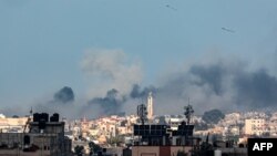 FILE - This picture taken from Rafah shows smoke billowing over Khan Younis in the distance following Israeli bombardment on the southern Gaza Strip on February 14, 2024.