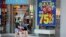 FILE - Two girls walk past a store with sale signs displayed at Great Lakes Mall, June 10, 2020, in Mentor, Ohio. Sales for retailers have plunged since the coronavirus pandemic. 