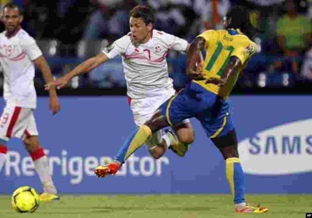 Tunisia's Youssef Msakni (L) challenges Moise Brou Apanga of Gabon during their African Cup of Nations Group C soccer match at Franceville stadium in Gabon January 31, 2012.