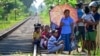 People wait for the arrival of the Ocean Queen train carrying family members of people killed in the 2004 Indian Ocean tsunami, for a memorial service in Peraliya on Dec. 26, 2024, on the 20th anniversary of the disaster. 