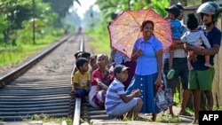 People wait for the arrival of the Ocean Queen train carrying family members of people killed in the 2004 Indian Ocean tsunami, for a memorial service in Peraliya on Dec. 26, 2024, on the 20th anniversary of the disaster. 