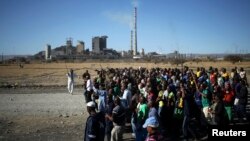 Miners chant slogans as they march past the Lonmin mine during the one-year anniversary commemorations to mark the killings of 34 striking platinum miners shot dead by police outside the Marikana platinum mine in Rustenburg, Aug. 16, 2013.