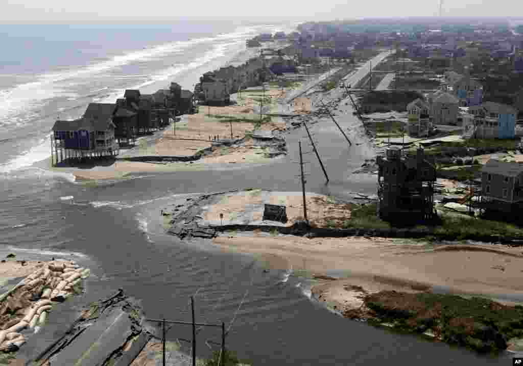 A flooded road is seen in Hatteras Island, N.C., Sunday, Aug. 28, 2011, after Hurricane Irene swept through the area Saturday cutting the roadway in five locations.