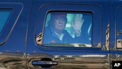 President Donald Trump waves to supporters from his motorcade as people gather for a march, Nov. 14, 2020.
