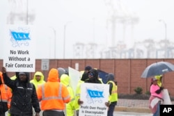 Dockworkers strike at the entrance to a container terminal at the Port of Baltimore, Oct. 1, 2024, in Baltimore.