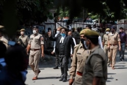 Vimal Kumar Srivastava, defense counsel in the 1992 attack and demolition of a 16th century mosque, displays the victory symbol as he leaves a court in Lucknow, India, Sept. 30, 2020.