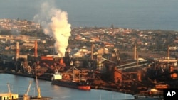 FILE - In this July 2, 2014 file photo, smoke billows out of a chiming chimney stack of BHP steel works at Port Kembla, south of Sydney, Australia. 