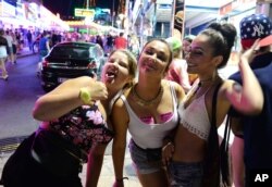 FILE - Tourists react as they pose for a photo at the resort of Magaluf, in Calvia town, on the Spanish Balearic island of Mallorca, June 10, 2015.