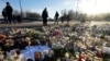 People gather at a makeshift memorial near the scene of a shooting on the outskirts of Orebro, Sweden, Feb. 7, 2025. 