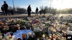 People gather at a makeshift memorial near the scene of a shooting on the outskirts of Orebro, Sweden, Feb. 7, 2025. 