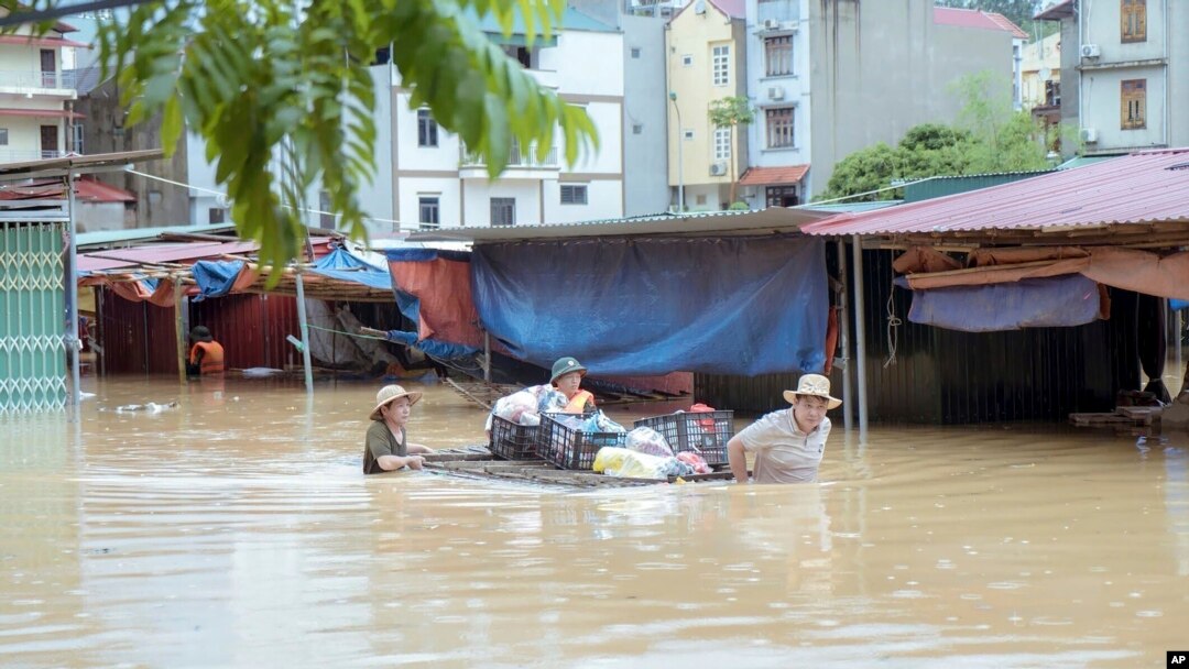 People carry belongings in flood triggered by Typhoon Yagi in Lang Son province, Vietnam, Sept. 9, 2024.
