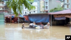 People carry belongings in flood triggered by Typhoon Yagi in Lang Son province, Vietnam, Sept. 9, 2024.