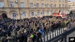 Protesters gather outside the parliament building of the Georgian separatist region of Abkhazia as tensions flared over a proposed measure that would allow Russians to buy property in the region, in Sukhumi, Georgia, on Nov. 15, 2024. (AIASHARA Independent Agency via AP)