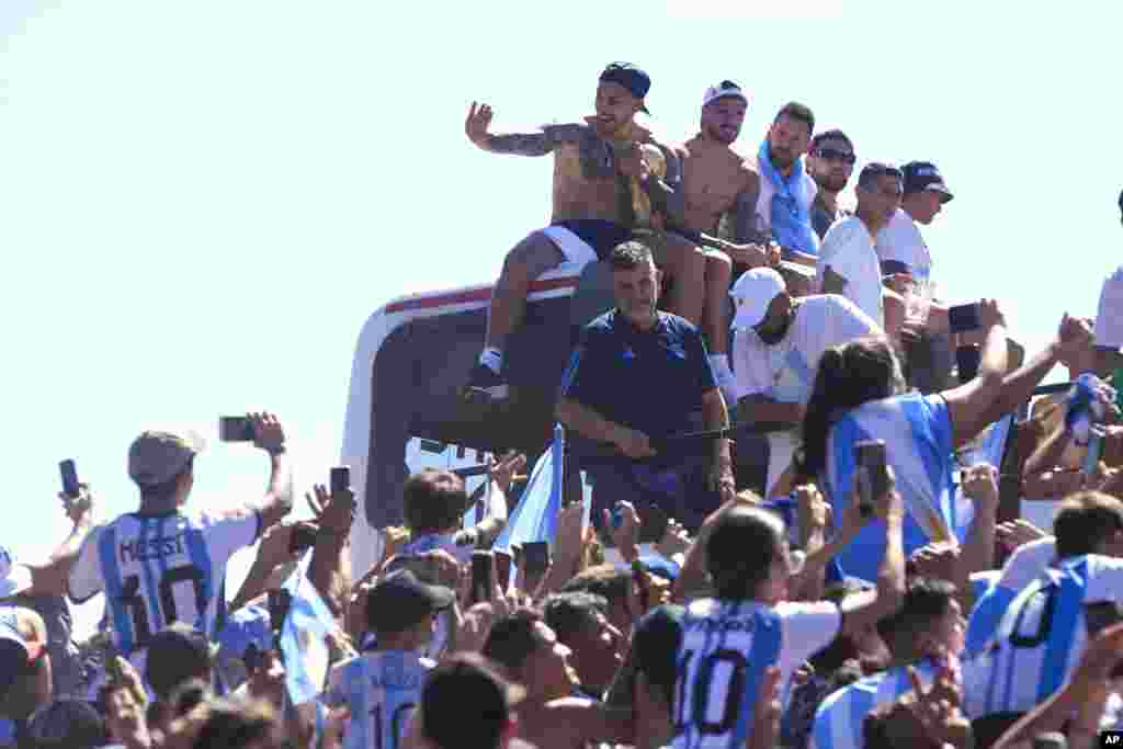 Pemain timnas Argentina antara lain Leandro Paredes, Rodrigo De Paul, Lionel Messi dan Nicolas Otamendi duduk di atas bus dalam parade kemenangan Piala Dunia di Buenos Aires, Selasa (20/12). (Foto: AP)&nbsp;