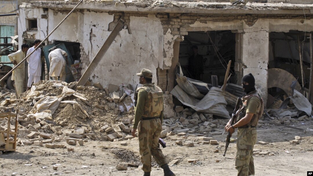 Warga memeriksa lokasi tempat meledaknya bom dalam serangan di Darra Adam Khel, propinsi Khyber Pakhtunkhwa perbatasan Afghanistan (13/10).