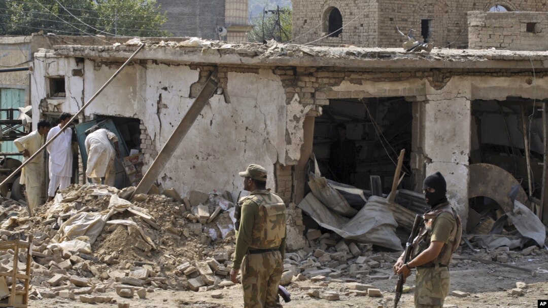 Pakistani men check the damage caused by a car bomb explosion at the site in the town of Darra Adam Khel in the troubled Khyber Pakhtunkhwa province bordering Afghanistan, October 13, 2012. 