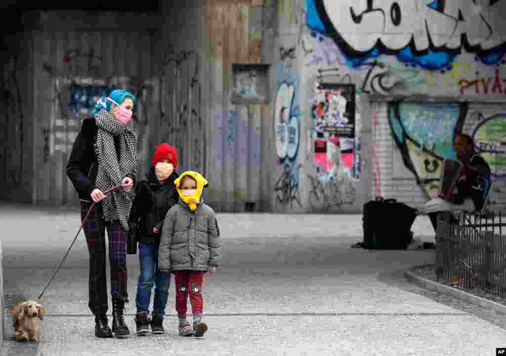 A woman and her children walk their dog in Prague, Czech Republic. Due to the outbreak of the novel coronavirus, the Czech capital banned all passengers without face protection from public transportation.