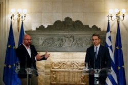 European Council President Charles Michel, left, makes statements after his meeting with Greece's Prime Minister Kyriakos Mitsotakis at Maximos Mansion in Athens, Sept. 15, 2020.