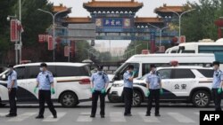 Para petugas kepolisian berjaga di depan Pasar Xinfadi yang terpapar virus corona (Covid-19), Beijing, 13 Juni 2020.