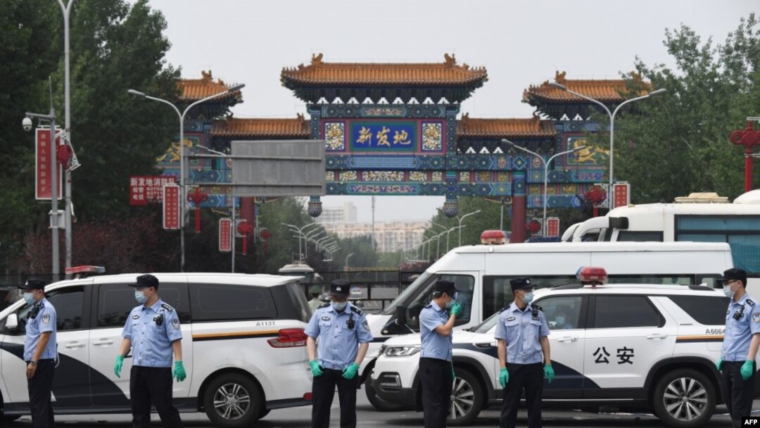 中国警察在被关闭的北京新发地农产品批发市场的入口处站岗。（2020年6月13日）