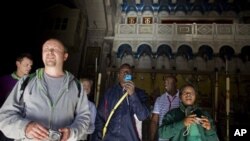 A Nigerian tourist, center, takes a picture as he exits the Church of the Holy Sepulcher, the site traditionally believed by Christians to be the tomb of Jesus, in Jerusalem's Old City, 27 Dec 2010