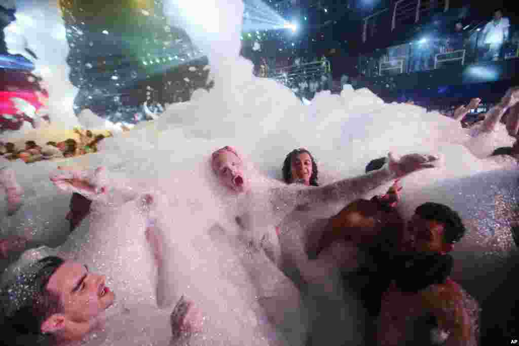 Anak-anak yang sedang liburan musim semi terbalut busa di klub malam The City di kota resor Karibia, Cancun, Mexico.