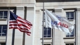 FILE PHOTO: An American flag and USAID flag fly outside the USAID building in Washington