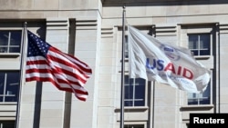 FILE PHOTO: An American flag and USAID flag fly outside the USAID building in Washington