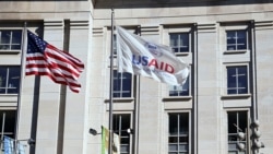 FILE: Bendera Amerika dan bendera USAID berkibar di luar gedung USAID di Washington, D.C.