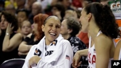 FILE - The United States' Diana Taurasi, left, laughs with Sue Bird from the bench during an exhibition basketball game against China, April 26, 2018, in Seattle. 
