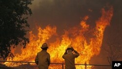 Firefighters from around the state battle a large wildfire on Highway 71 near Smithville, Texas. A roaring wildfire raced unchecked Monday through rain-starved farm and ranchland in Texas, destroying nearly 500 homes during a rapid advance fanned in part