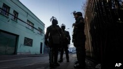 ARCHIVO - La policía vigila un área durante una operación organizada por la alcaldía de Santiago y la policía chilena en el centro de la capital chilena ante el auge de la violencia, el martes 13 de junio de 2023.