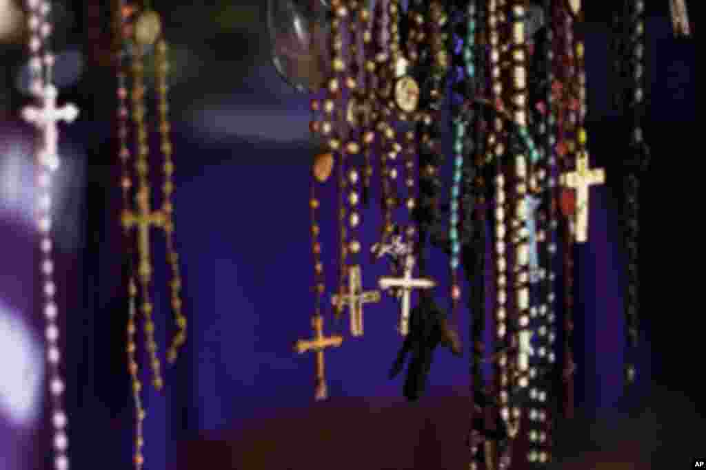Crucifixes hang among the personal possessions of Rwandan victims at a genocide memorial inside the church at Ntarama just outside the capital Kigali, August 6, 2010. Some 5,000 people, mostly women and children, sought refuge near the church in April 199