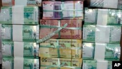 FILE - Sudan's new currency sits behind a window at the central bank in Khartoum, Sudan.