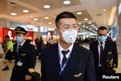 China Eastern Airlines flight crew wear protective masks on arrival at Sydney International Airport in Sydney, Australia, Jan. 23, 2020.