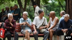 FILE- Elderly people rest at a park in Fuyang in eastern China's Anhui province on September 13, 2024. China said on September 13 it would gradually raise its statutory retirement age, as the country grapples with an older population. (Photo by AFP)