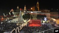 Christian worshippers and tourists celebrate at the Manger Square in front of the Church of the Nativity, in the West Bank town of Bethlehem, December 24, 2012. 