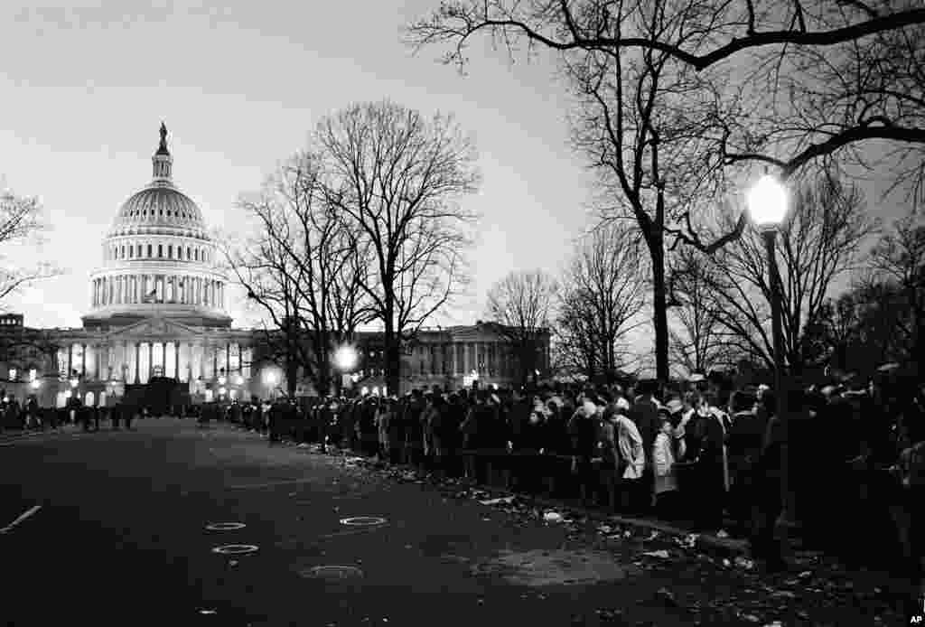 Warga yang berduka cita menunggu lewatnya rombongan yang membawa peti jenazah Presiden John F. Kennedy di pinggir jalan, 24 November 1963.