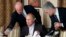 FILE - In this Nov. 11, 2011, photo, businessman Yevgeny Prigozhin, left, serves food to Russian Prime Minister Vladimir Putin, center, during dinner at Prigozhin's restaurant outside Moscow, Russia. 